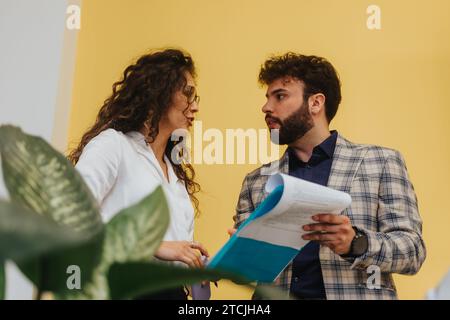 Multicultural couple colleagues collaborate in modern office, discussing innovative strategies for business growth. Stock Photo