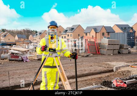 Surveyor builder site engineer with theodolite total station at construction site outdoors during surveying work Stock Photo