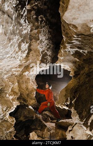 A portrait of a young female caver exploring the cave. Stock Photo