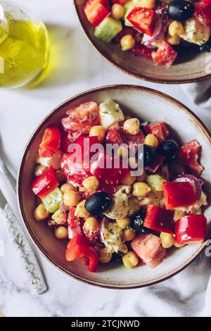 Healthy rich protein Greek salad with tomatoes, bell pepper, cucumber, black olives, feta cheese, onion and chickpeas Stock Photo