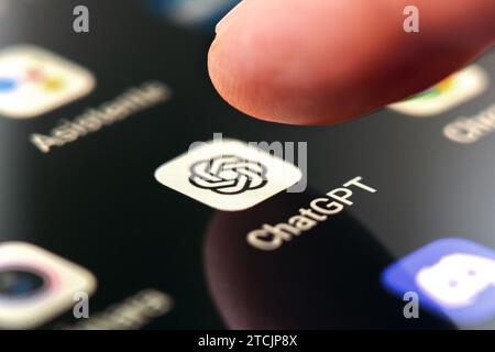 Oviedo, Spain - December, 13, 2023: ChatGPT app icon on smartphone screen with pushing finger. Artificial intelligence chatbot service on mobile phone Stock Photo