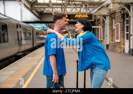 Beautiful couple at railway station waiting for the train. Woman and man running to board a train Stock Photo
