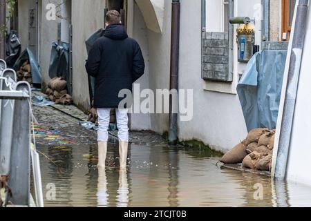 Passau, Germany. 13th Dec, 2023. A man stands in the floodwater of the Danube. The flood situation remains tense in parts of Bavaria. Credit: Armin Weigel/dpa/Alamy Live News Stock Photo