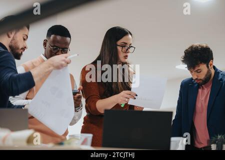 Business Professionals Collaborating on Data Analysis and Financial Planning Late at Night. Stock Photo