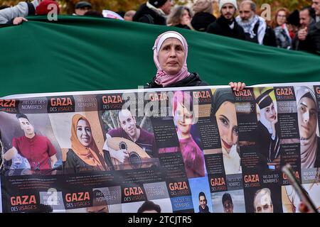 Marseille, France. 9th Dec, 2023. A Palestinian female protester holds a banner showing photos with the names of victims of Israeli bombings during the demonstration. First banned by the Bouches-du-RhÃ´ne police headquarters due to serious risks of disturbing public order, the demonstration for a ceasefire in Gaza took place without incident following a decision by the Administrative Court. (Credit Image: © Gerard Bottino/SOPA Images via ZUMA Press Wire) EDITORIAL USAGE ONLY! Not for Commercial USAGE! Stock Photo