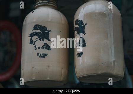 Two white historical sake bottles on display Stock Photo