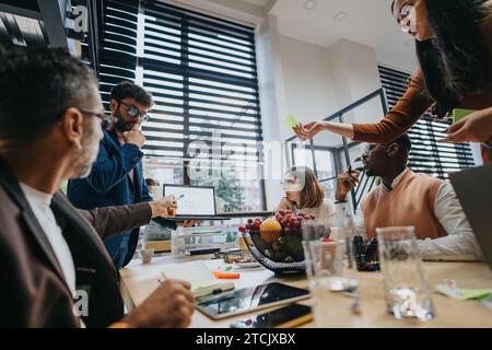 Businesspeople collaborating in a creative office, working on a project and discussing market analysis and financial planning. Stock Photo
