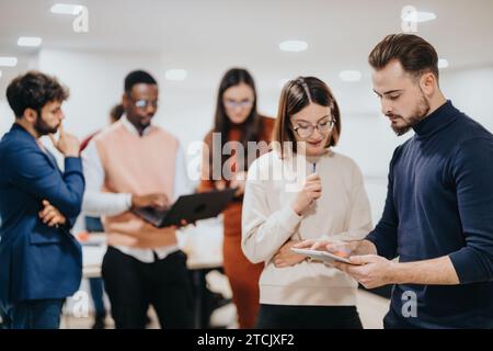 Diverse team working late to meet deadline, analyze data, and achieve business growth. Stock Photo