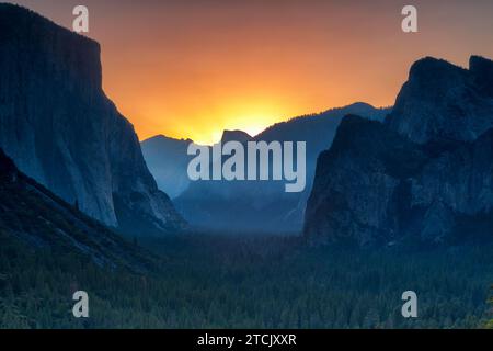 Classic Tunnel View of scenic Yosemite Valley with famous El Capitan and Half Dome rock climbing summits in beautiful golden morning light at sunrise Stock Photo