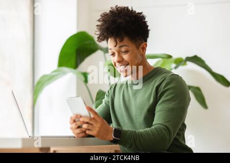 Black guy independent contractor working at cafe, using gadgets Stock Photo