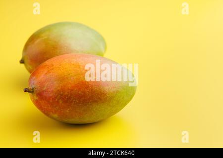 Ripe mango fruit on the yellow background. Stock Photo