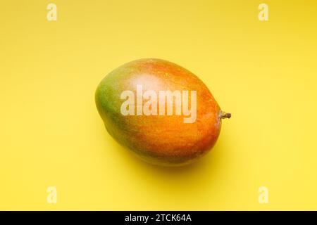Ripe mango fruit on the yellow background. Top view. Stock Photo