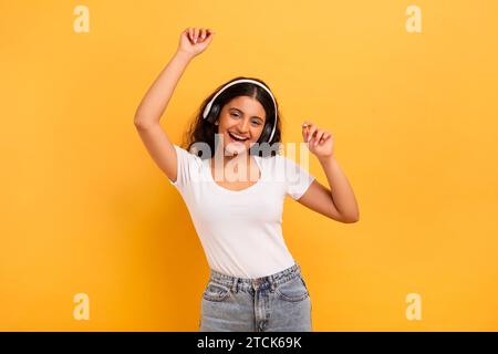Cute young indian woman listening to music and dancing Stock Photo