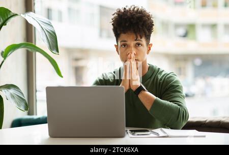 Portrait of concentrated young black guy entrepreneur working at cafe Stock Photo