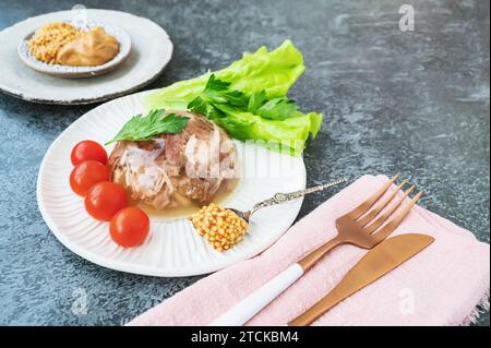 Homemade jellied meat with mustard and horseradish on the table. Aspic. Homemade jelly with mustard, tomatoes and garlic on the table. Kholodets, trad Stock Photo