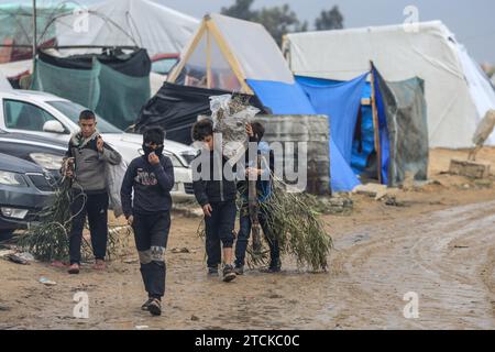 Rafah, Palestinian Territories. 13th Dec, 2023. Palestinians walk near makeshift tents at camp for displaced people. Credit: Mohammed Talatene/dpa/Alamy Live News Stock Photo