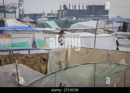 Rafah, Palestinian Territories. 13th Dec, 2023. A Palestinian child stands near his family's makeshift tent at camp for displaced people. Credit: Mohammed Talatene/dpa/Alamy Live News Stock Photo