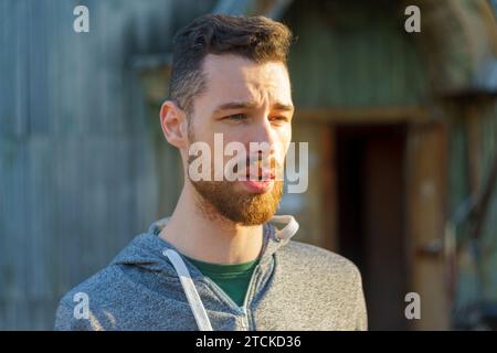Stylish Man in a Grey Sweatshirt, portrait of a young millennial with a beard. Stock Photo