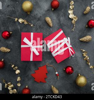 Merry christmas composition with gift boxes and golden decoration with red balls on dark background. Flat lay, top view Stock Photo