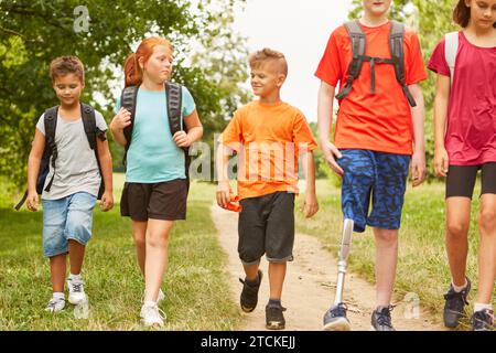 Male and female friends walking with disabled boy on footpath at forest Stock Photo