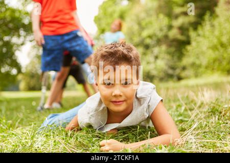 Portrait of boy lying down on grass while playing at park Stock Photo