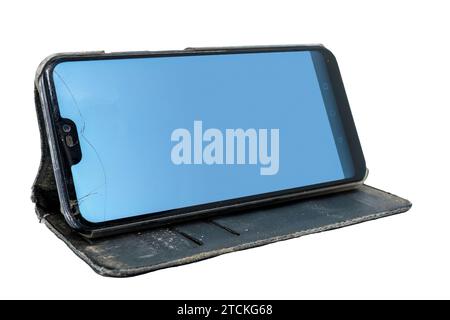 Used smart phone with cracked screen in a flip case, placed in horizontal position. Isolated on white background with clipping path Stock Photo