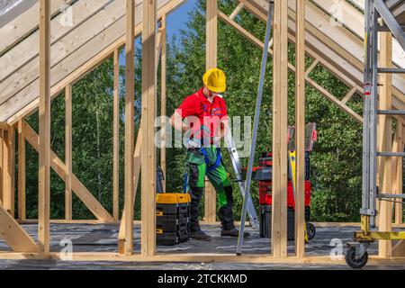 Construction Site Contractor Worker Wearing Hard Hat Between Wooden Skeleton Frame of the Building Stock Photo