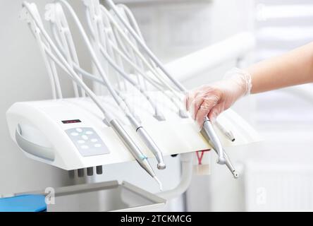 Dentist takes a tool in his hand. Various types of dental equipment in dental office. Stock Photo
