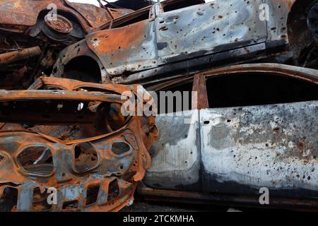 A dump of shot and burned cars as a result of the Russian invasion of Ukraine. War in Ukraine. Close up. Stock Photo