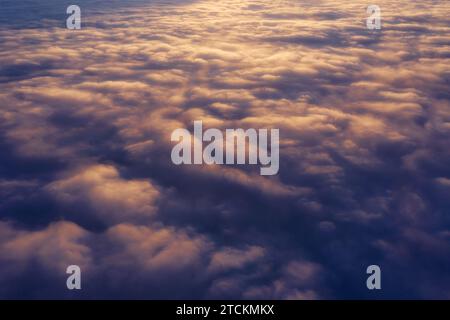 Beautiful dramatic landscape of fluffy clouds in the sky at sunset from aerial drone view. Sky background. Stock Photo