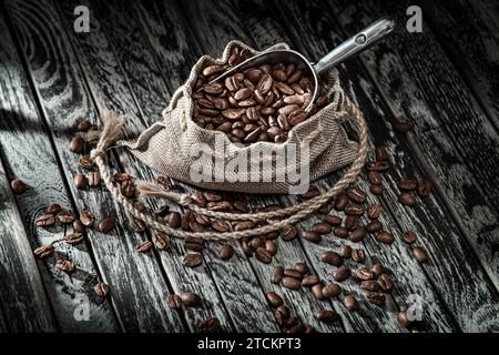 Coffee Beans In Burlap Bag And Scoop On Vintage Wood Stock Photo