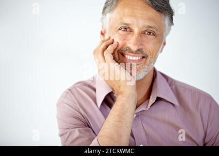 Happy, portrait and mature businessman in a studio with positive, good and confident attitude. Smile, pride and face of professional Indian male Stock Photo