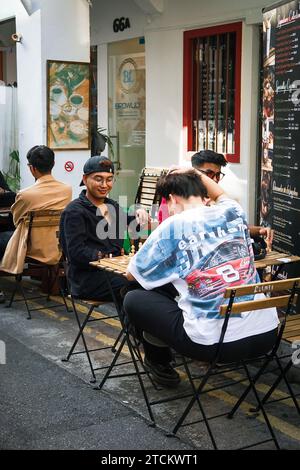 A diverse group of people enjoying a meal together outside of a restaurant Stock Photo