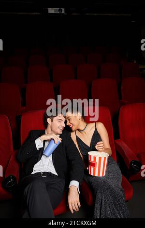 appealing cheerful couple in evening attires having great time at cinema on date, Valentines day Stock Photo