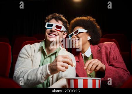 joyous interracial couple with retro 3d glasses having great time at cinema on date, Valentines day Stock Photo