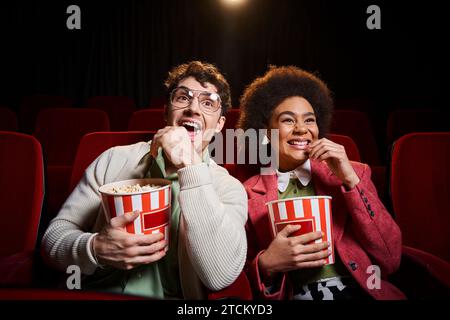 cheerful young diverse couple in retro attires with 3d glasses having great time on their date Stock Photo