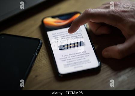 Clicking on download button on smartphone app Stock Photo