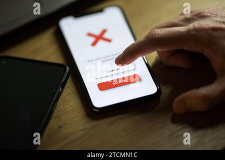 Clicking on red delete button on smartphone app Stock Photo