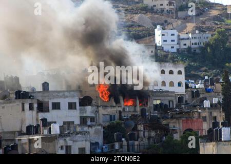 Jenin, Palestine. 13th Dec, 2023. Smoke rises from a Palestinian house in the Jenin refugee camp after it was targeted by the Israeli army. During a military operation inside Jenin camp searching for militants. Violence has escalated in the Palestinian territories since the war against Hamas in the Gaza Strip. Credit: SOPA Images Limited/Alamy Live News Stock Photo