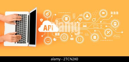 Female hands with laptop and virtual screen with abbreviation API on orange background Stock Photo
