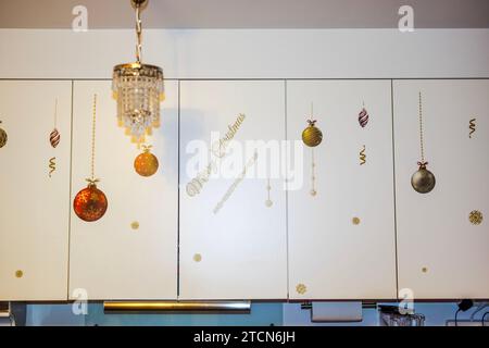 View of white kitchen cabinets adorned with Christmas decorative stickers. Sweden. Stock Photo