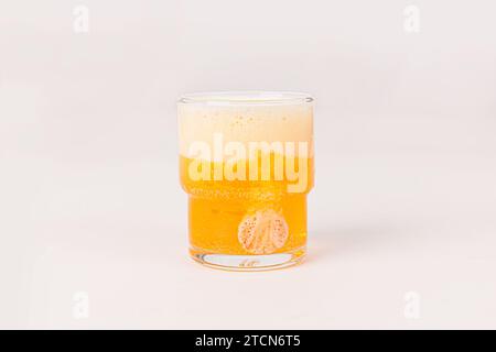 Orange vitamin C effervescent tablet dropped and dissolve in glass of water with bubbles isolated on white background Stock Photo