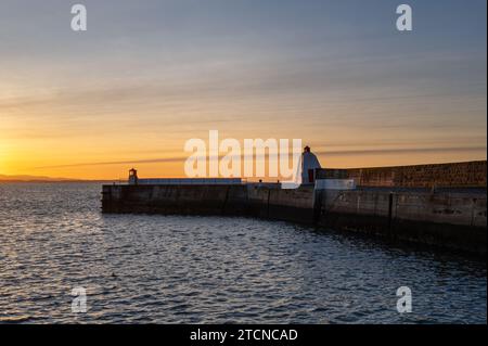 13 December 2023. Burghead, Moray, Scotland. This is a sunset glow on a December afternoon as the sun set viewed from Burghead Harbour. Stock Photo