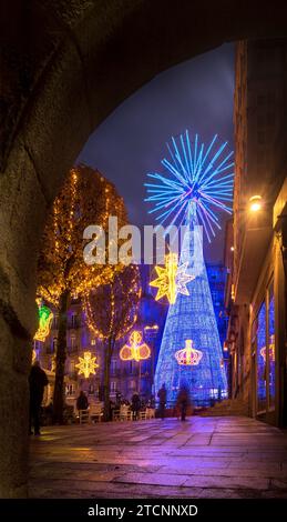 Vigo, Spain - December 10, 2023: Night view of the city square of Vigo in Spain, decorated with Christmas lights and in the background a huge luminous Stock Photo
