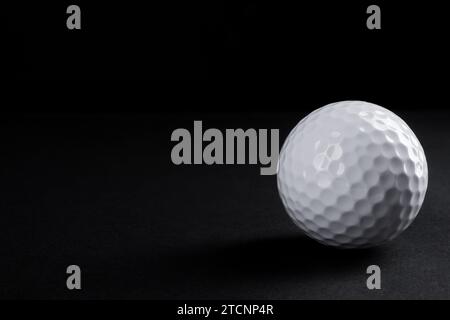 Golf ball on black background, space for text Stock Photo