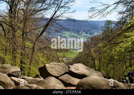 Lautertal, Germany - April 24, 2021: Rocks and trees overlooking small German village on a spring day at Felsenmeer in Germany. Stock Photo