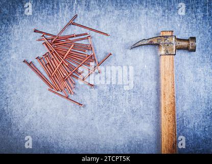 Assortment of vintage claw hammer copper construction nails on metallic background Stock Photo