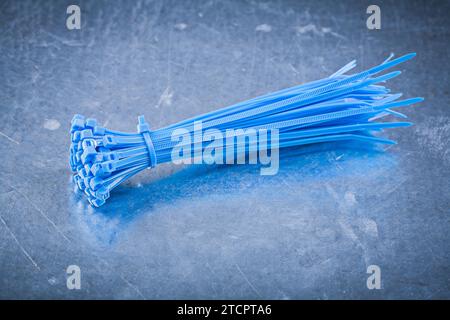Blue self-locking plastic cable ties on a metallic background Design concept Stock Photo