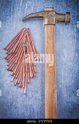 Composition of vintage claw hammer copper construction nails on metallic background Stock Photo