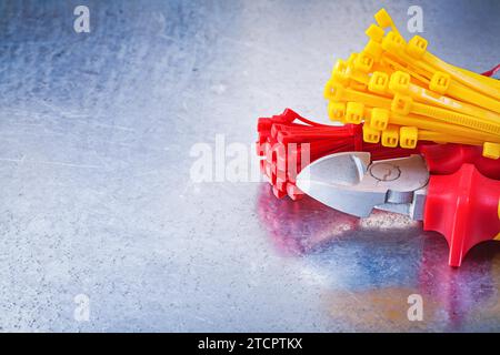 Pliers for cutting plastic cable ties on a scratched metallic background Stock Photo